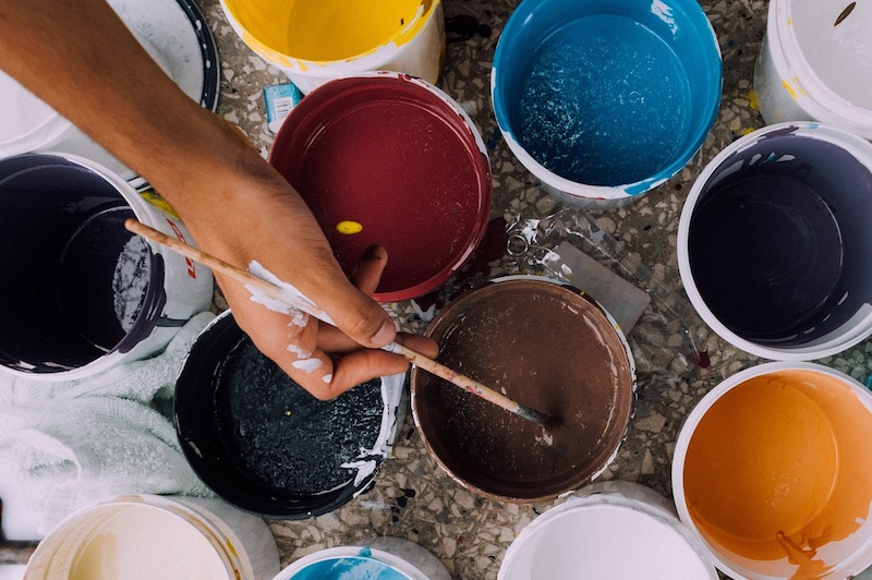 Potten met verf en hand van schilder